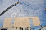 Crane lifting wall panel - stock photo